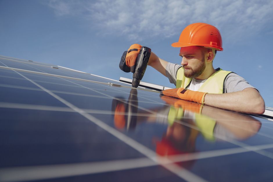Professional solar installation worker securing panels on a residential roof
